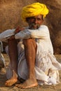 A camel farmer sits in sunset lights at Pushkar fair