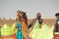 Camel herder owner stands near colorfully decorated camel in Gujarat India