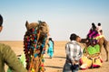 Camel herder owner stands near colorfully decorated camel in Gujarat India