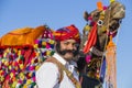 Camel and indian men wearing traditional Rajasthani dress participate in Mr. Desert contest as part of Desert Festival in Jaisalme