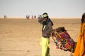 Camel owner herder standing with his colorfully decorated camel