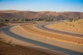 Camel Racing is an Arabian Gulf tradition. This camel race track shows the curve of the sandy track in the evening sun.