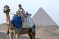 A camel and rider in front of the Pyramid of Khufu in Giza in Cairo, Egypt.