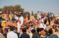 Camel riders with swords happy to see many people in the crowd Royalty Free Stock Photo