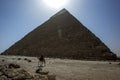 A camel walks past the Pyramid of Khafre at Giza in Cairo, Egypt. Royalty Free Stock Photo