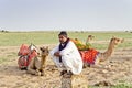 A Cameleer anxiously waits for tourists at Sam Desert, Jaisalmer, Rajasthan, India Royalty Free Stock Photo