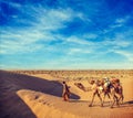 Cameleer camel driver with camels in dunes of Thar desert. Raj