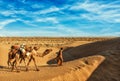 Cameleer camel driver with camels in dunes of Thar