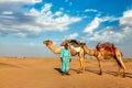 Cameleer camel driver with camels in dunes of Thar