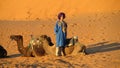 Cameleer with camels in desert