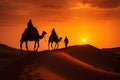 Cameleers guide camels through Thar Desert at picturesque sunset