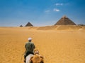 A CamelMan Riding to the Pyramids