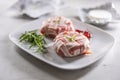 Camembert or brie cheeses wrapped in bacon with fresh rosemary and chilli on a white plate Royalty Free Stock Photo