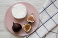 Camembert or brie with figs on a pink plate over white wooden background, top view. Flat lay, overhead, from above. Close-up Royalty Free Stock Photo