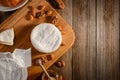 Camembert cheese, almond, walnuts and honey on wooden background Royalty Free Stock Photo