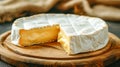 Camembert cheese with cut out slice on wood board. Creamy buttery texture white moldy rind. Traditional French cuisine specialty