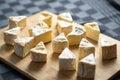 Camembert cheese cut into triangles on a wooden cutting board on a dark background Royalty Free Stock Photo