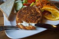 Camembert cheese with fried crust lies on a white plate, a piece cut off. Royalty Free Stock Photo