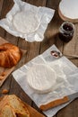 Camembert cheese, jam and croissant on a rustic wooden table