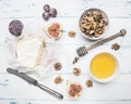 Camembert cheese on old wooden table with a bowl of walnuts, honey, a vintage table knife, cut figs grapes, top view Royalty Free Stock Photo