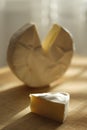 Camembert cheese slice and other whole part on a wooden table