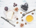 Camembert cheese on white wrapping paper, with jam, walnuts and honey, fresh figs, on a rustic wooden background, top view Royalty Free Stock Photo