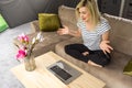 Camera approaching joyful positive Caucasian young beautiful woman sitting in apartment on sofa typing on laptop surfing Royalty Free Stock Photo