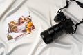 Camera and colorful printed photos of women on desk close up