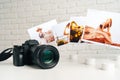 Camera and colorful printed photos of women on desk close up