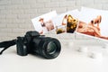 Camera and colorful printed photos of women on desk close up