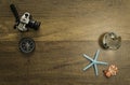 Camera and compass decorate on wooden table with starfish world glass marble and turtle Royalty Free Stock Photo