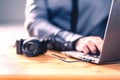 Camera connected to laptop with usb cable. Man editing photos with computer software. Photographer transfer files to computer. Royalty Free Stock Photo