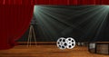 Camera with film reels on stage with red drape curtains Royalty Free Stock Photo