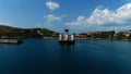 Camera flying towards the long pier with an old building with three towers. Shot. Aerial view of a blue sea coast with a Royalty Free Stock Photo