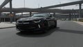 Drone camera follows black sport car on the road in Meydan, Dubai