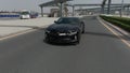 Drone camera follows black sport car on the road in Meydan, Dubai