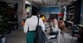 Camera follows successful young black female boss entering diverse office team meeting, talk to colleagues with coffee.