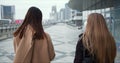 Camera follows two Caucasian female doctors wearing face masks walking along empty city street on epidemic quarantine.