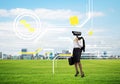 Camera headed woman standing on green grass against modern cityscape