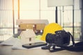 Camera with  helmet Construction plans ,pem ,phone and blueprints on wooden table Royalty Free Stock Photo