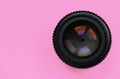 Camera lens with a closed aperture lie on texture background of fashion pastel pink color paper in minimal concept