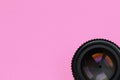 Camera lens with a closed aperture lie on texture background of fashion pastel pink color paper in minimal concept