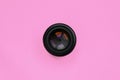 Camera lens with a closed aperture lie on texture background of fashion pastel pink color paper in minimal concept