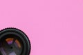 Camera lens with a closed aperture lie on texture background of fashion pastel pink color paper in minimal concept