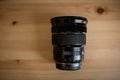 The camera lens on light wooden table Royalty Free Stock Photo