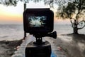 Camera mounted on a tripod photograph the pier and sunrise. Close up, view on screen Royalty Free Stock Photo