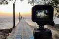 Camera mounted on a tripod photograph the pier and sunrise, Focus on screen Royalty Free Stock Photo