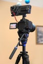 Camera mounted on the tripod ready for shooting. Photographic equipment Royalty Free Stock Photo