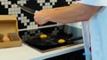 Camera moving back from young woman breaking eggs in cooking pan preparing breakfast in kitchen. Caucasian beautiful Royalty Free Stock Photo