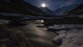 Time-lapse of moon, mountain valley and river. moonrise. snow-capped mountains